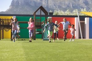 Front view of multi ethnic students running in school playground